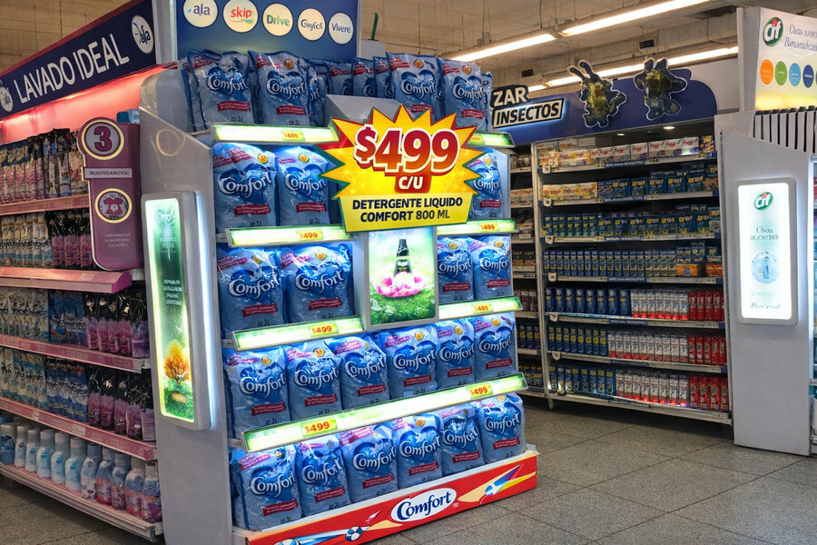 Exhibidor promocional de detergente Comfort con precio destacado en supermercado.