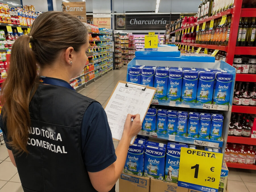 Auditoría comercial - Auditor revisando exhibición de productos en supermercado