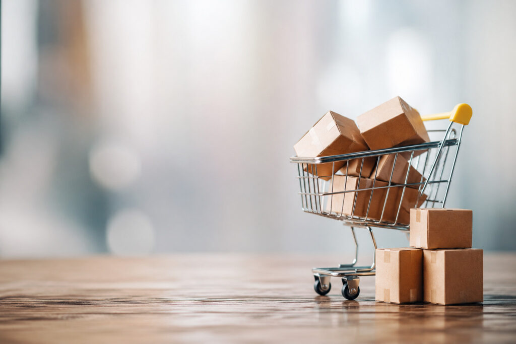 Frecuencia de compra introduccion - Carrito de compras con cajas sobre mesa minimalista.
